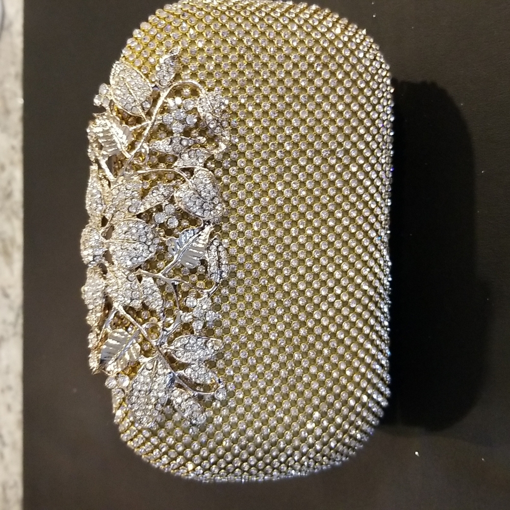 Women evening bag in gold color with crystals.